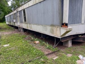 A weathered mobile home with a 
